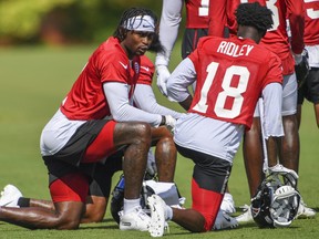 FILE: Atlanta Falcons wide receiver Julio Jones (11) talks to wide receiver Calvin Ridley (18) on the field during the first day of training camp at Falcons Training Complex on July, 2019. /