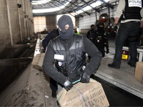 Police officers unload from a truck packages containing drugs before destroying them on February 23, 2010 in Gonesse, a suburb of Paris. Seven tons of cannabis were seized by French police on January 31, 2010 and seven people were arrested after an investigation between Morocco and Spain.