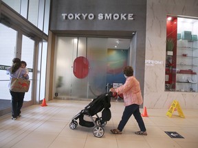 FILE - Devonshire Mall shoppers walk by the Tokyo Smoke cannabis store on Friday, July 9, 2021.