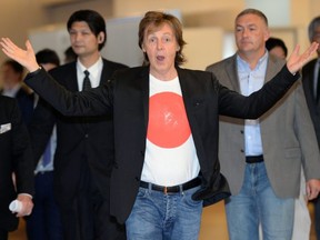 FILE: Paul McCartney greets fans and journalists upon his arrival at the Haneda airport in Tokyo on May 15, 2014. /