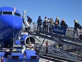 FILE: Passengers board a Southwest Airlines airplane at Hollywood Burbank Airport in Burbank, California, October 10, 2021.