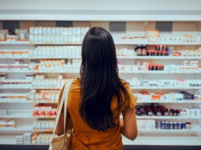 A woman looks at the pharmacy shelf.