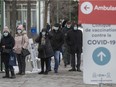 People line up for their COVID-19 vaccine at the St-Laurent vaccination centre on Ste-Croix Ave. on Dec. 27, 2021.