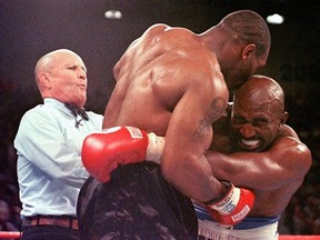 FILE: Referee Lane Mills (L) steps in as Evander Holyfield (R) reacts after Mike Tyson bit his ear in the third round of their WBA heavyweight championship fight at the MGM Grand Garden Arena in Las Vegas, NV 28 June. Holyfield won by disqualification after the biting incident.