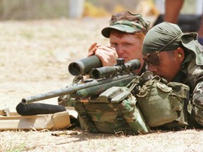 FILE PHOTO: A U.S. Marine instructs a Philippine soldier on how to use a sniper rifle on the first day of a two-week military exercise with the Philippine military Apr. 24, 2002 at the Marine Base in Ternate, Cavite province in the Philippines. /