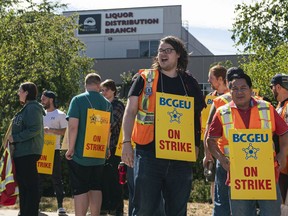 FILE - B.C. General Employees' Union workers set up a picket line after going on strike at a B.C. Liquor Distribution Branch wholesale and distribution centre in Delta.