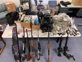 Police photo of recovered drugs, cash and weapons. /