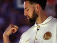 FILE - Klay Thompson #11 of the Golden State Warriors inspects his championship ring during a ceremony prior to the game against the Los Angeles Lakers at Chase Center on October 18, 2022 in San Francisco, California.