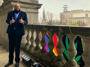 John Fetterman poses with marijuana and LGBTQ flags outside of his office in Pennsylvania.