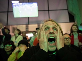 FILE - A fan reacts while watching the final football match of the Qatar 2022 World Cup between Argentina and France on a screen at "Polye" culture space in Moscow, on December 18, 2022