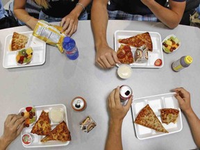 FILE - Image for representation. Spain Park High School students have lunch including whole wheat pizza, baked chips, yogurt, low calorie drinks and fresh fruit in the school's cafeteria in Hoover, Ala., Aug. 31, 2007.