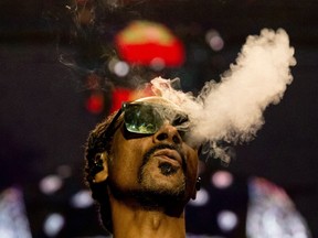 FILE - US rapper Calvin Cordozar Broadus Jr aka Snoop Dogg blows smoke as he performs on stage at the Accor Arena of Bercy, in Paris, on March 25, 2023.