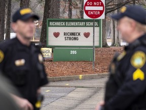 FILE - Police look on as students return to Richneck Elementary following a school shooting in which a 6-year-old boy shot his teacher, Jan. 30, 2023, in Newport News, Va. The mother of the 6-year-old boy who shot his teacher in Virginia is now facing federal charges that allege she used marijuana while also possessing a gun, which is illegal under U.S. law.