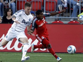 TORONTO, CANADA - JUNE 29:  Joao Plata #7 of Toronto FC gets pushed by Wes Knight #8 of Vancouver Whitecaps FC during MLS action at BMO Field June 29, 2011 in Toronto, Ontario, Canada. (Photo by Abelimages/Getty Images)