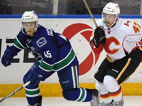 Jordan Schroeder (left) checks Calgary Flames Sven Baertschi (right) during game action at the 2011 Young Stars Tournament held in Penticton on September 12, 2011. The Vancouver Canucks, Calgary Flames, Edmonton Oilers, Winnipeg Jets and San Jose Sharks prospects teams are participating in the tournament. (Photo by Larry Wong/Edmonton Journal/Postmedia News Service)