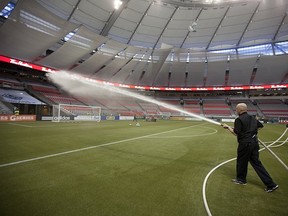 VANCOUVER, CANADA - OCTOBER 12:  The field crew at BC Place sprays the field with water before the MLS game between the Vancouver Whitecaps FC and D.C. United at BC Place October 12, 2011 in Vancouver, British Columbia, Canada.  Vancouver won 2-1.(Photo by Jeff Vinnick/Getty Images)
