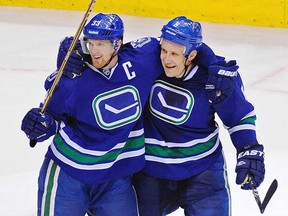 The fans' first star, Sami Salo (right), receives congratulations from Henrik Sedin after his overtime goal beat the Minnesota Wild on Saturday at Rogers Arena.