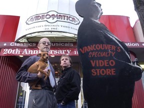 Videomatica founder and owner Graham Peat (left) holding 'Java' stands next to co-owner Brian Bosworth and the store's original Alfred Hitchcock cut-out. (Arlen Redekop/PNG Archive)