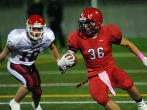 W.J. Mouat's Tanner Strauss (left) pursues STM running back Sebastian Adugalski on Friday at Burnaby Lakes. (Steve Bosch, PNG)