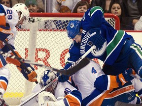 Ryan Kesler crashes into Mark Eaton (4) and Evgeni Nabokov while trying to jam the puck in the net this past week. Photo Courtesy of Sports.Yahoo.Com  Rich Lam/ Getty Images