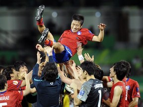 Teammates toss Lee Young-Pyo in the air after beating Uzbekistan for third place in the Asian Cup in January. (PORNCHAI KITTIWONGSAKUL/AFP/Getty Images)