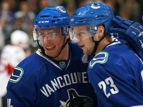 VANCOUVER — Alex Burrows congratulates Alex Edler after the Canucks defenceman collects another point. He's third among NHL blueliners with a dozen points after 12 games. (Getty Images via National Hockey League.)