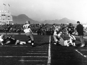 Angelo Mosca (No. 68) of the Hamilton Tiger-Cats tackling Willie Fleming (in black jersey) of the B.C. Lions out of bounds during the 1963 Grey Cup game at Empire Stadium in Vancouver. (PNG Archive)