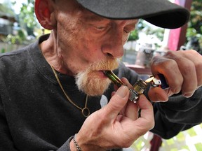 Ross Hubbs, who has Alzheimer's and is taken care of by his wife Lorraine,  smokes marijuana at their home in Aldergrove.  ARLEN REDEKOP/PNG FILES