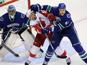 Andrew Alberts (right) roughs up Tomas Holmstrom during the Canucks' 4-2 win Wednesday over the Detroit Red Wings. (Steve Bosch/PNG)