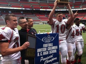 John Barsby quarterback Brody Taylor (10) hoists the hardware after the Bulldogs hung on to beat Mission in the Subway Bowl Double A junior varsity final. (PNG photo)