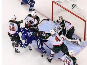 VANCOUVER, CANADA - OCTOBER 22: Ryan Kesler #17 of the Vancouver Canucks gets pushed by Clayton Stoner #4 of the Minnesota Wild after scoring the goal in the second period at Rogers Arena on October 22, 2011 in Vancouver, British Columbia, Canada. (Photo by Derek Leung/Getty Images) [PNG Merlin Archive]