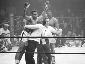 In this May 25, 1965 photo, heavyweight champion Muhammad Ali is lifted in jubilation after his rematch with boxer Sonny Liston. Ali knocked out Liston in the first round of the match to retain his title. (MCT FILES)