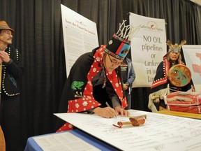 Chief  Nam'Oks signs a letter at a ceremony last month cementing opposition to Enbridge's proposed Northern Gateway pipeline. (PNG FILES )