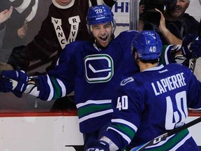 Chris Higgins (left) celebrates a goal against the Washington Capitals with teammate Maxim Lapierre. Their performances on Oct. 29 were the top two of the season's first half, according to your votes.  (Ric Ernst / PNG)