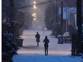 Snow falls as people wake to a wintry day in the laneways of Vancouver Saturday, Jan. 14. (Ward Perrin, PNG)