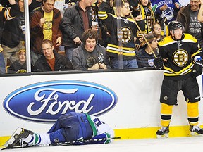 Bruins fans react gleefully and Brad Marchand of the Boston Bruins just stands there after a brutal check against Sami Salo of the Vancouver Canucks at the TD Garden on January 7, 2012 in Boston, Mass. Salo would leave the game and is now out indefinitely with concussion-like symptoms.