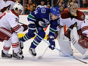 Alex Burrows (14) of the Vancouver Canucks gets tripped up in front of goalie Jason Labarbera (1) the Phoenix Coyotes in NHL hockey at Rogers Arena in Vancouver, February 13, 2012. The were tied after the first period 0-0.