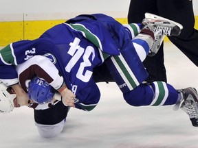 Vancouver Canucks Byron Bitz (right) fights against Colorado Avalanche Cody McLeod in first period NHL play at Rogers Arena in Vancouver, Feb. 15. (Ian Lindsay/PNG)
