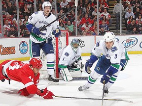 Kevin Bieksa #3 of the Vancouver Canucks reaches for the puck with Todd Bertuzzi #44 of the Detroit Red during an NHL game at Joe Louis Arena on February 23, 2012 in Detroit, Michigan. (Dave Reginek/NHL/Getty Images)