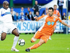 Former RailHawks forward Etienne Barbara (R) signed with the Whitecaps on Tuesday. In action here against ex-Whitecap Nelson Akwari.