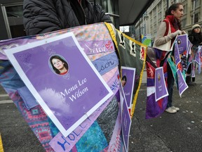 People form a circle holding names and photos of the missing during a rally Monday on West Georgia Street in Vancouver outside the Missing Women Inquiry. Given that case and others, is there a public appetite in giving police more control over the criminal charge approve system in B.C.? (Arlen Redekop/ PNG)