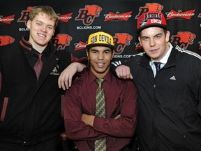 Mason Woods (left) of Terry Fox, and Tom Clarkson of Mission flank Victoria-Mt. Douglas' Terrell Davis during NCAA Div, signing day ceremonies in Vancouver. (Les Bazso, PNG photo)