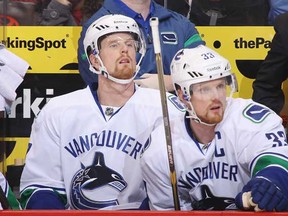 Daniel (left) and Henrik Sedin watch from the bench during a November game in Phoenix. (Christian Petersen/Getty Images)