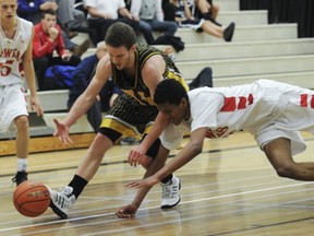 W.J. Mouat's Tristan Etienne (right) dives for loose ball against Kelowna point guard Mitch Goodwin. (PNG photo)