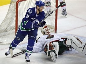 Vancouver Canucks' Henrik Sedin, left, of Sweden, celebrates a goal by Alex Burrows (not pictured) as Minnesota Wild's Niklas Backstrom, of Finland, lays on the ice during the first period of an NHL hockey game in Vancouver, British Columbia on Tuesday, March 3, 2009. (AP Photo/The Canadian Press, Darryl Dyck)