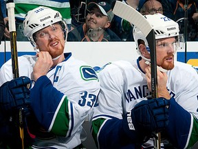 Henrik Sedin #33 and Daniel Sedin #22 of the Vancouver Canucks put on their helmets before a game against the Edmonton Oilers at Rexall Place on February 19, 2012 in Edmonton, Alberta, Canada. (Photo by Andy Devlin/NHLI via Getty Images)