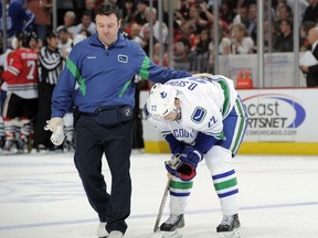 Vancouver's Daniel Sedin is helped off the ice after taking an elbow to the head from Chicago Blackhawk Duncan Keith during Wednesday night's game.