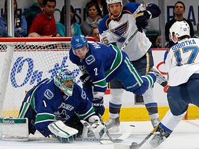 Roberto Luongo #1 of the Vancouver Canucks reaches out to stop Vladimir Sobotka #17 of the St. Louis Blues while Dan Hamhuis #2 of the Canucks and Chris Stewart #25 of the Blues eye the puck during their NHL game at Rogers Arena March 1, 2012 in Vancouver, British Columbia, Canada. (Jeff Vinnick/NHL via Getty Images)