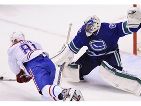 Vancouver Canucks goalie Roberto Luongo stretches out as Montreal Canadiens Lars Eller attempts a shot