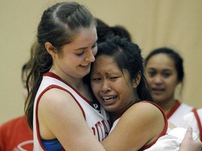 Helen Wilson, left, hugs emotional teammate Jennifer Carpio after their team, Britannia Bruins, captured the Provincial AA title Saturday night at the TCC. MURRAY MITCHELL/THE DAILY NEWS